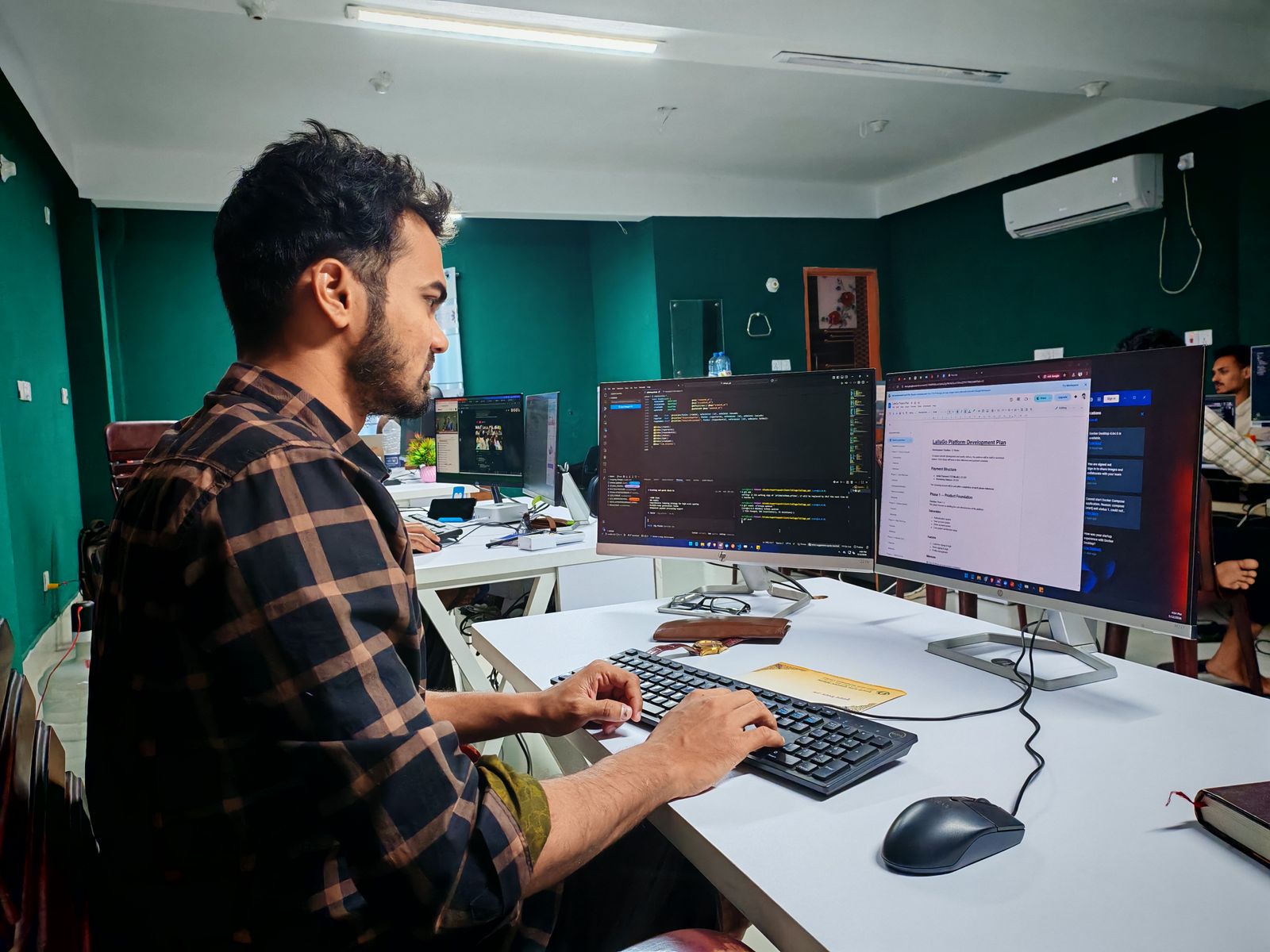 A developer building the product on a dual-monitor setup
